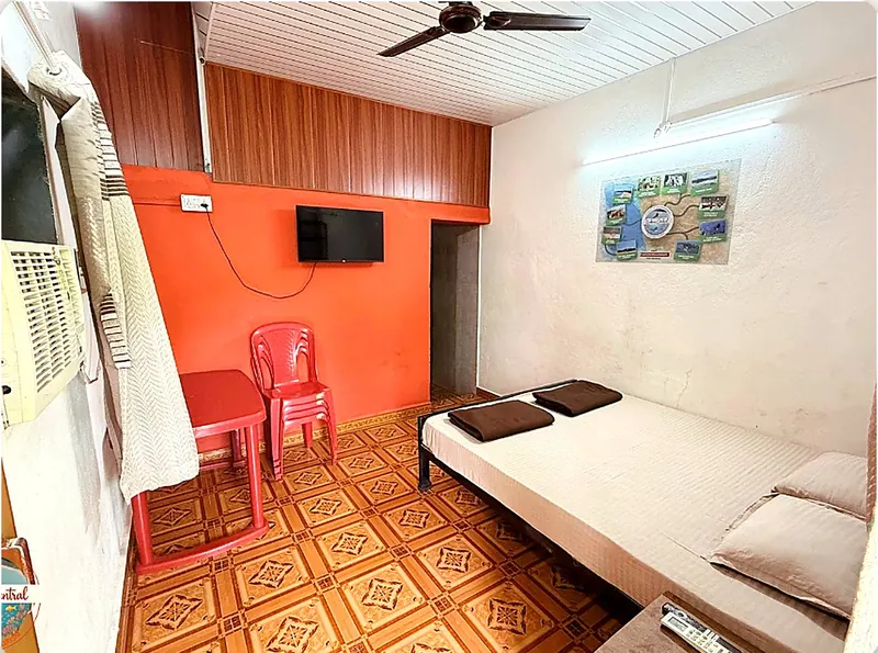 Room 1 at Konkan Central Homestay, Kankavli: queen bed and orange wall