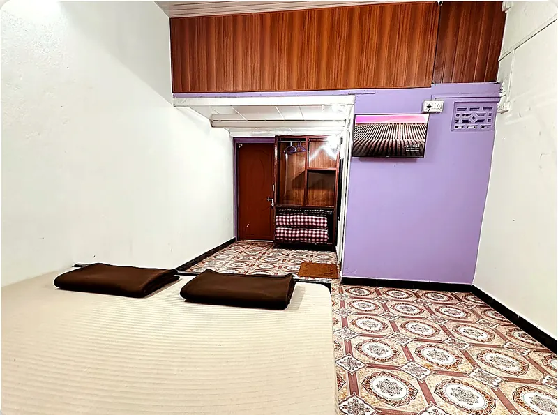 Room 3 at Konkan Central Homestay, Kankavli: king bed and split AC on the lilac wall